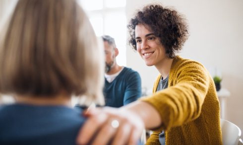 Men and women sitting in a circle during group therapy, supporting each other. Vacatures 3